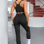 Black athletic workout set consisting of a racerback sports bra and high-waisted leggings