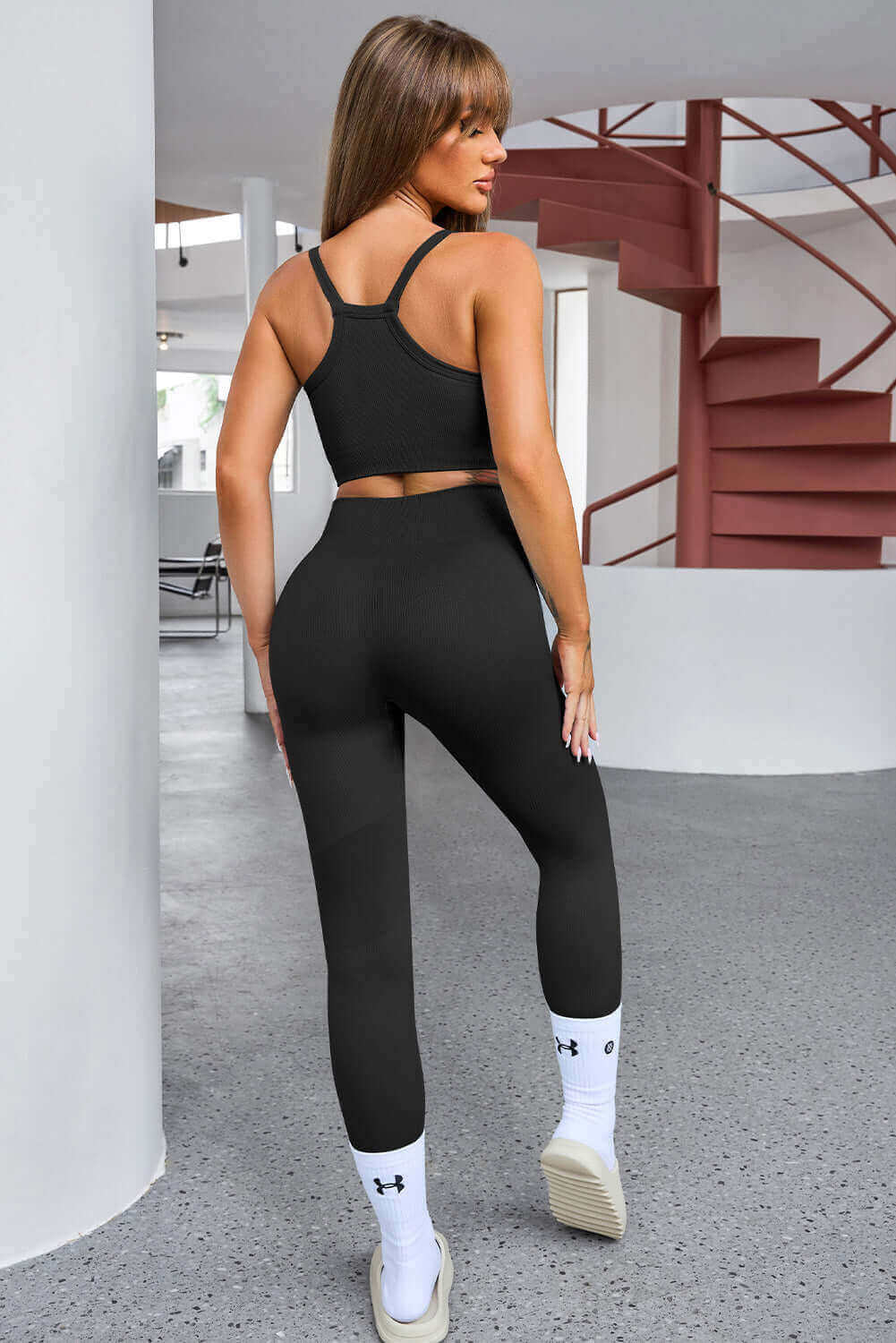 Black athletic workout set consisting of a racerback sports bra and high-waisted leggings