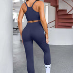 Navy blue workout set consisting of a sports bra and high-waisted leggings with white socks and sneakers